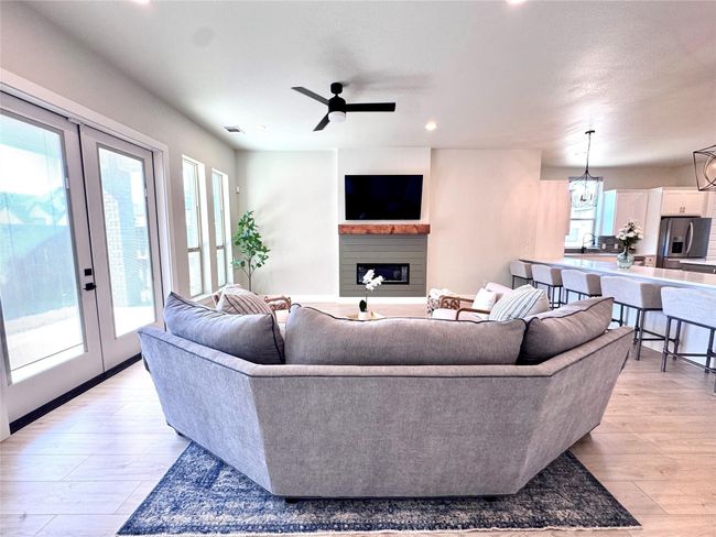 Living area featuring french doors, a fireplace, light wood-style floors, a ceiling fan, and recessed lighting | Image 13