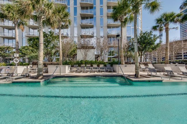 View of swimming pool with fence and a patio | Image 19