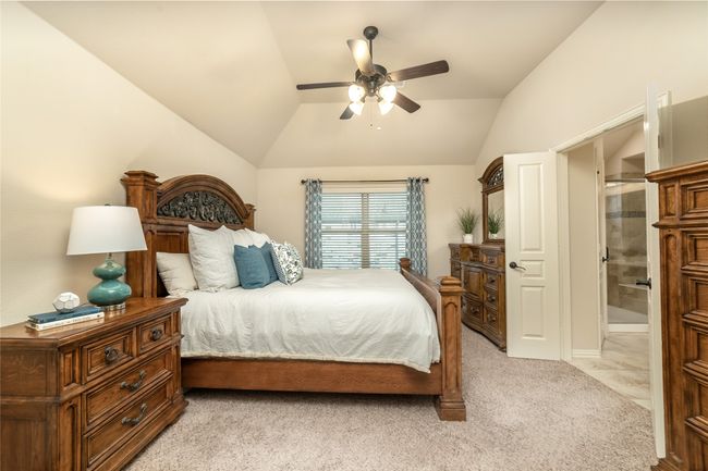 Bedroom with lofted ceiling, light carpet, and ceiling fan | Image 25