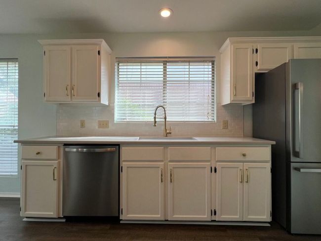 Kitchen with freestanding refrigerator, dishwasher, light countertops, white cabinetry, and recessed lighting | Image 13