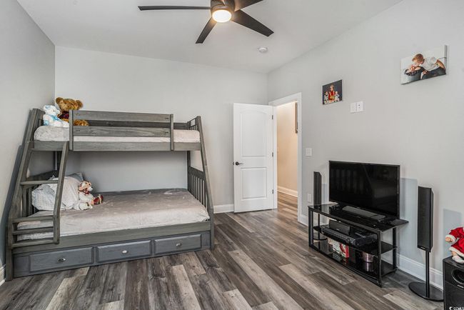 Bedroom featuring dark wood finished floors, baseboards, and ceiling fan | Image 19