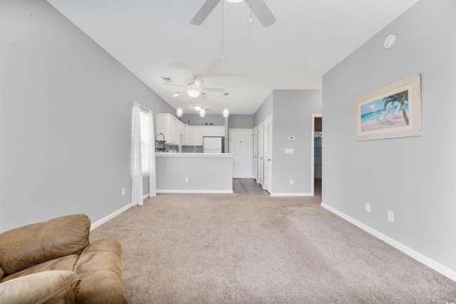 Living room featuring ceiling fan, light carpet, and baseboards | Image 10