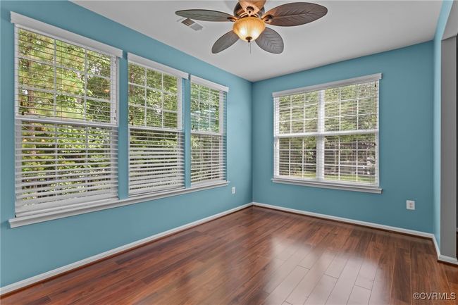 Empty room with a ceiling fan and wood finished floors | Image 15