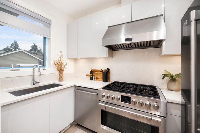 Kitchen featuring under cabinet range hood, modern cabinets, appliances with stainless steel finishes, and a sink | Image 12
