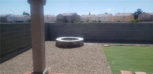 View of yard with an outdoor fire pit, a residential view, and a fenced backyard | Image 11