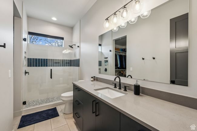 Full bathroom with a shower stall, toilet, vanity, and tile patterned flooring | Image 51