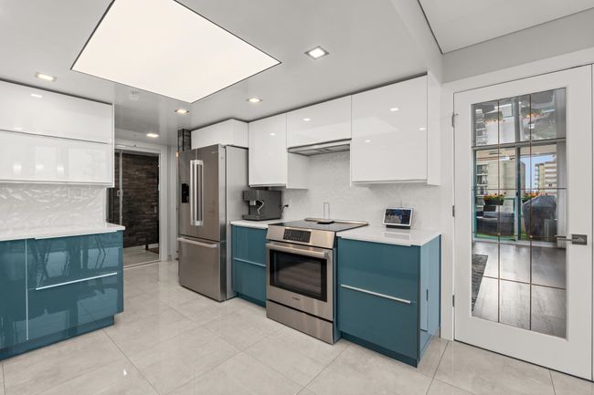 Kitchen featuring light countertops, blue cabinets, modern cabinets, stainless steel appliances, and white cabinets | Image 15