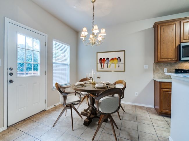 Dining room featuring a chandelier and light tile patterned floors | Image 4
