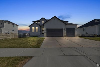 View of front of home with a garage, cooling unit, and a lawn | Image 1