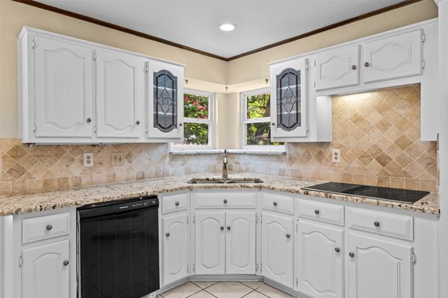 Kitchen featuring black electric cooktop, white cabinets, recessed lighting, and crown molding | Image 20