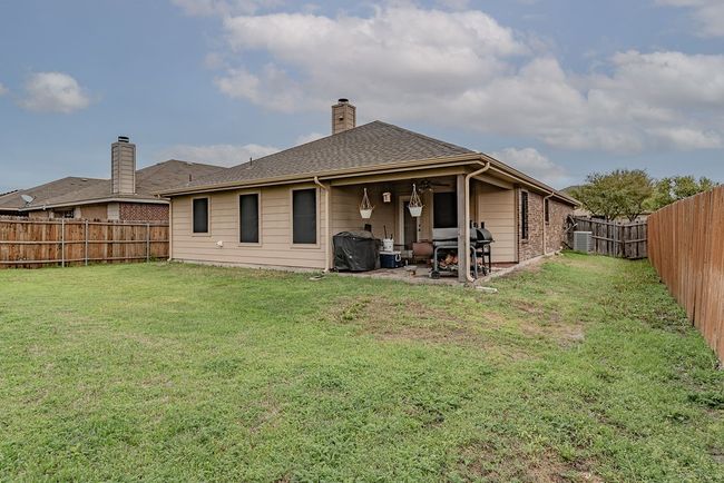 Back of house featuring a patio area, a ceiling fan, a chimney, a fenced backyard, and a yard | Image 18