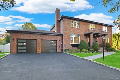 View of front of home featuring a front yard, a garage, and a balcony | Image 3