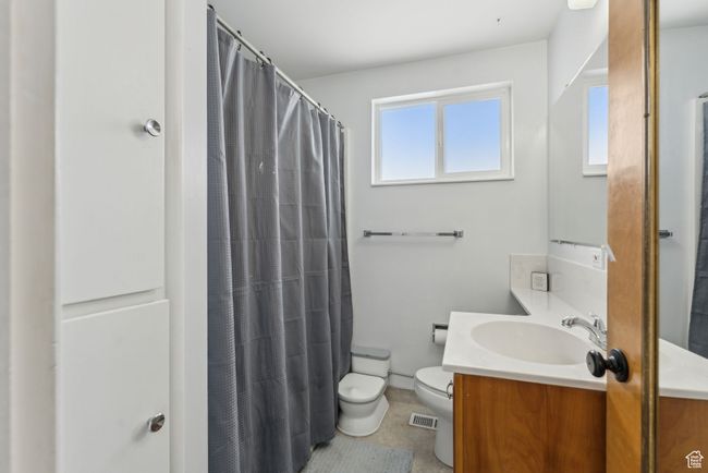 Full bath with visible vents, toilet, vanity, a shower with curtain, and baseboards | Image 15