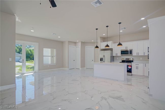 Kitchen featuring marble finish floor, visible vents, appliances with stainless steel finishes, and a kitchen island | Image 4