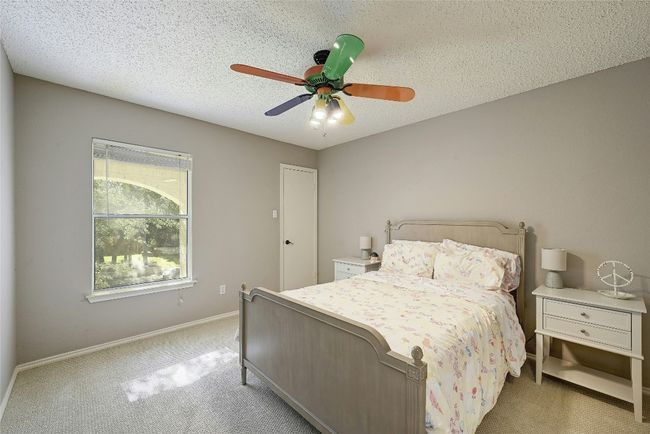 Bedroom featuring light carpet, a ceiling fan, and a textured ceiling | Image 22