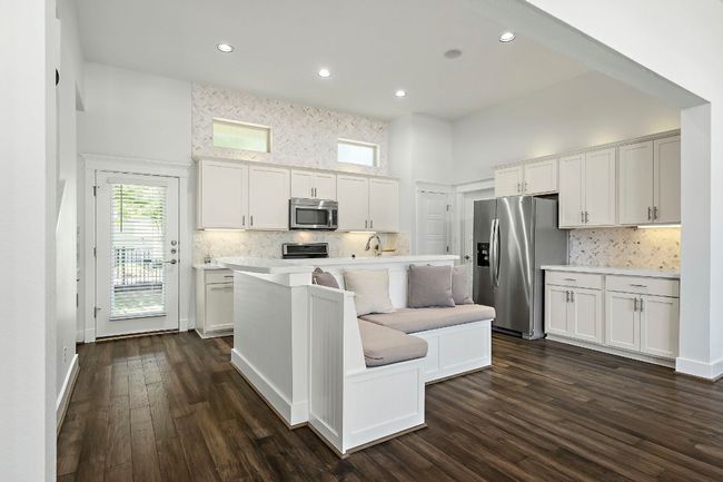 Kitchen featuring a sink, appliances with stainless steel finishes, light countertops, a towering ceiling, and backsplash | Image 10