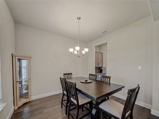 Dining area featuring dark wood-type flooring and a chandelier | Image 6