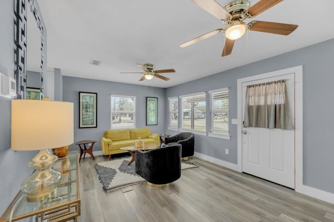 Living area featuring baseboards, visible vents, wood finished floors, and ceiling fan | Image 9