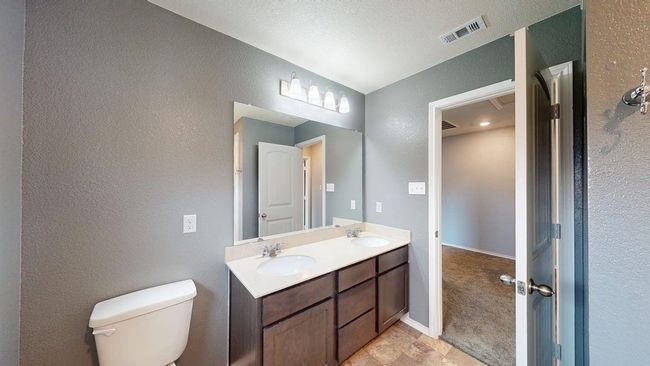 Full bathroom featuring toilet, a textured wall, visible vents, and a sink | Image 33