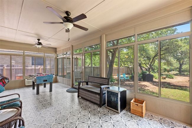 Enjoy outdoor living without the bugs—your screened-in porch overlooks the serene backyard and greenspace. | Image 16
