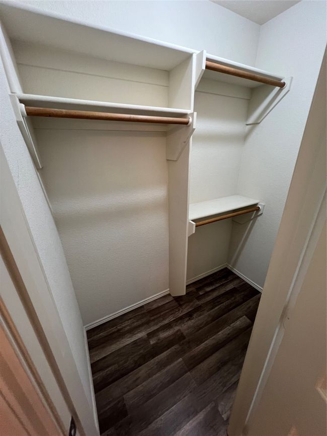 Walk in closet featuring dark wood-style floors | Image 34