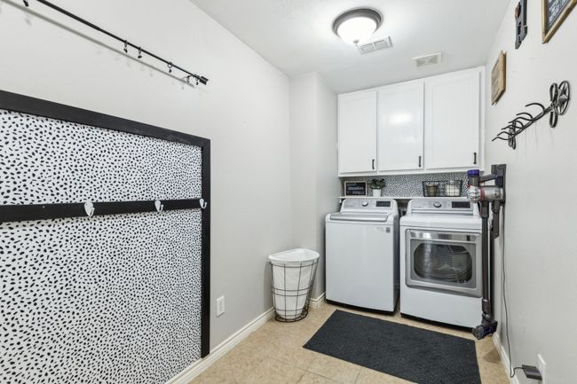 Washroom with cabinet space, baseboards, visible vents, and washer and dryer | Image 28