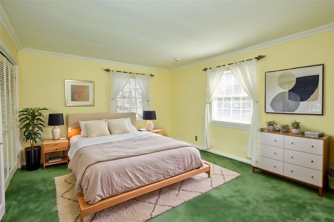Bedroom with dark carpet, a closet, and ornamental molding | Image 11