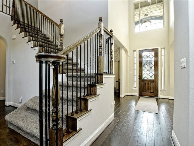 Foyer entrance with arched walkways, dark wood-type flooring, stairs, and a high ceiling | Image 7