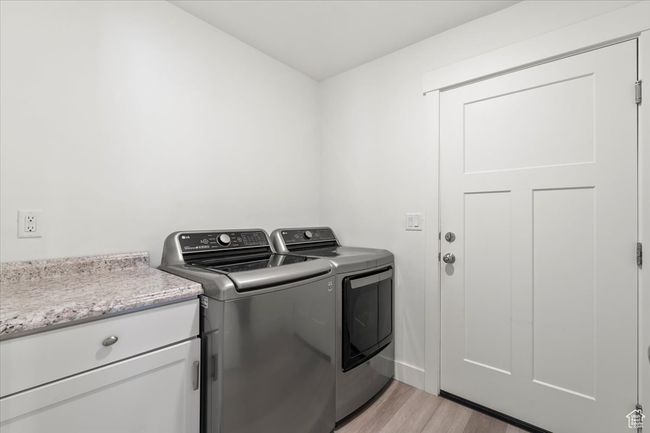 Laundry area with separate washer and dryer and light wood-style flooring | Image 19
