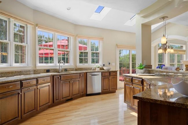 The kitchen features beautiful granite counters and stone backsplash. Notice all the windows framing fantastic views of the private rear yard. | Image 19