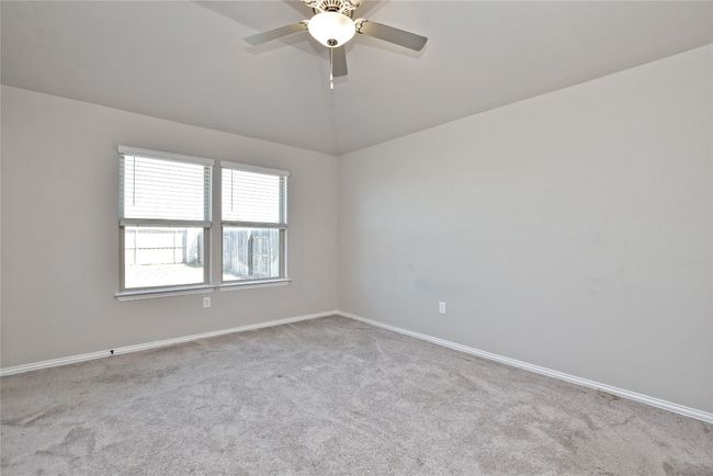 Empty room with lofted ceiling, carpet flooring, a ceiling fan, and baseboards | Image 14