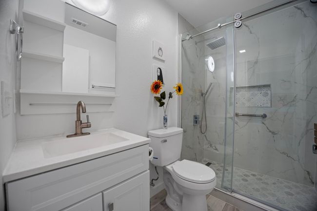 Bathroom with vanity, a marble finish shower, and wood finished floors | Image 15