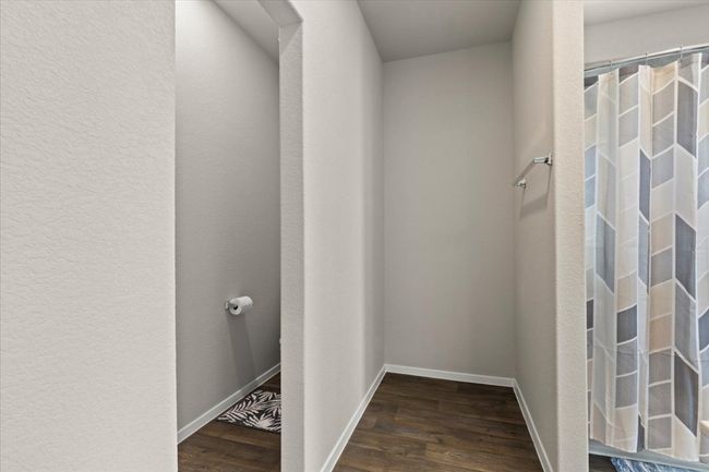 Bathroom featuring wood finished floors, baseboards, and a shower with shower curtain | Image 22