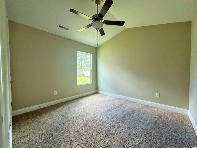 Dining room with baseboards, dark wood-style floors, vaulted ceiling, and ceiling fan with notable chandelier | Image 13