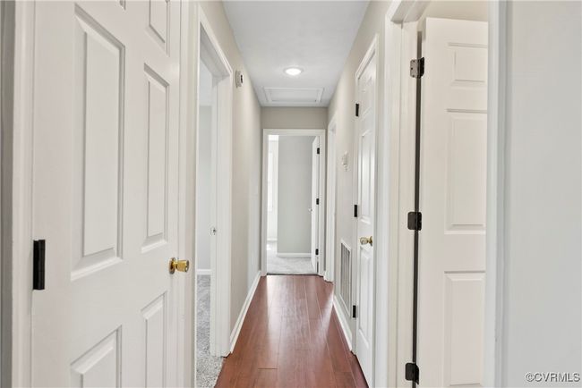 Corridor featuring dark wood finished floors, baseboards, and attic access | Image 16