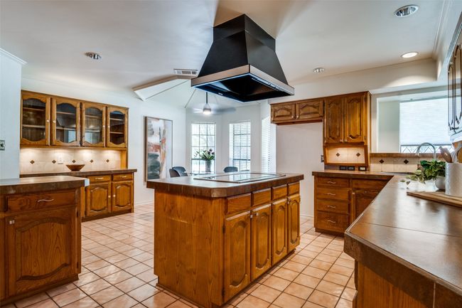 Kitchen with backsplash, dark countertops, ornamental molding, brown cabinets, and recessed lighting | Image 10