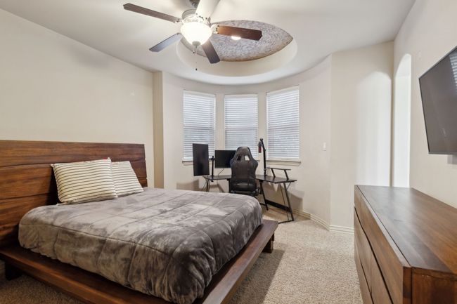 Bedroom featuring ceiling fan, light carpet, and baseboards | Image 22