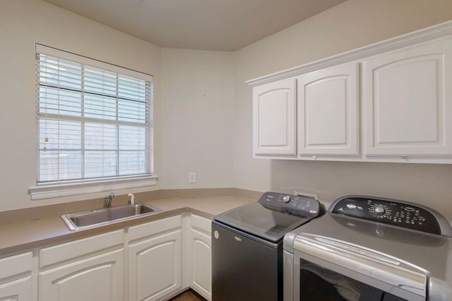 Laundry area with separate washer and dryer, a sink, and cabinet space | Image 30