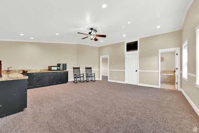 Interior space with ceiling fan, carpet floors, and crown molding | Image 43