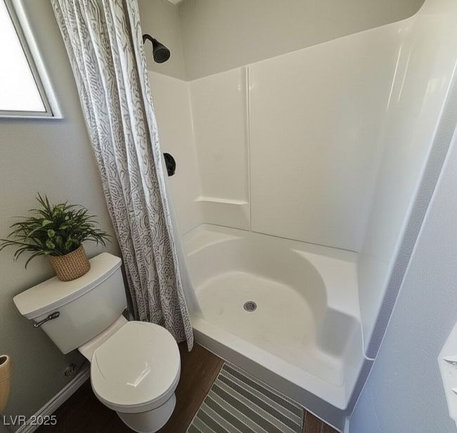 Bathroom featuring a shower stall and wood finished floors | Image 18