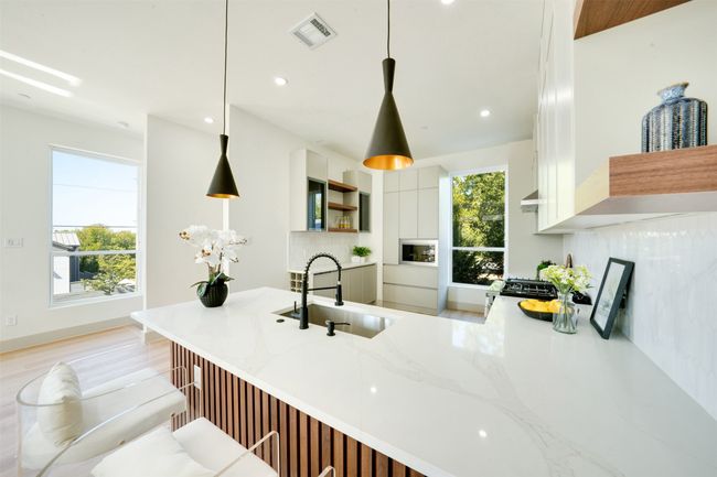 Kitchen with sink, light hardwood / wood-style flooring, decorative light fixtures, and white cabinets | Image 10