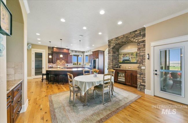 Dining area with wine cooler, light wood-type flooring, ornamental molding, and recessed lighting | Image 9