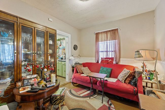 Living room with a wainscoted wall, a textured ceiling, and wood finished floors | Image 14