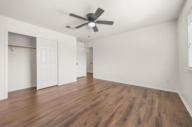 Unfurnished bedroom featuring baseboards, visible vents, a ceiling fan, a closet, and wood finished floors | Image 19