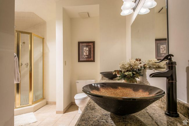 Bathroom featuring tile patterned floors, toilet, an enclosed shower, and dual sinks | Image 10