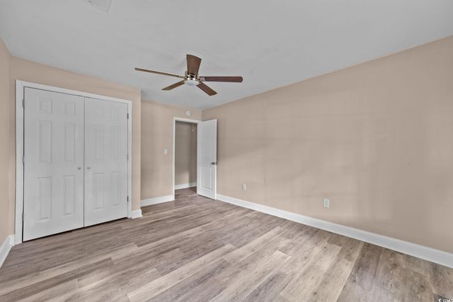 Unfurnished bedroom with wood finished floors, a closet, and a ceiling fan | Image 33