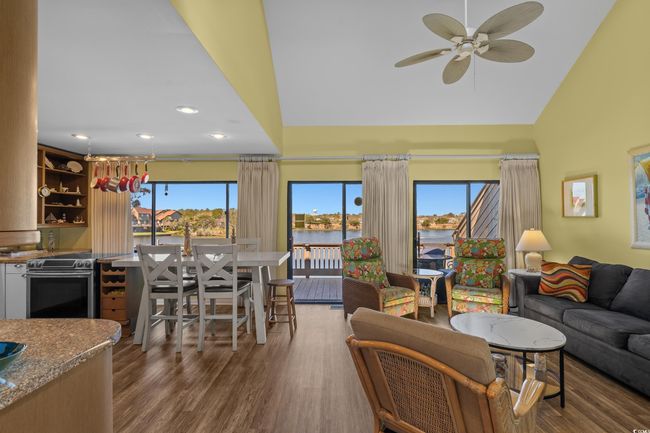 Living room featuring a water view, ceiling fan, wood finished floors, and recessed lighting | Image 8