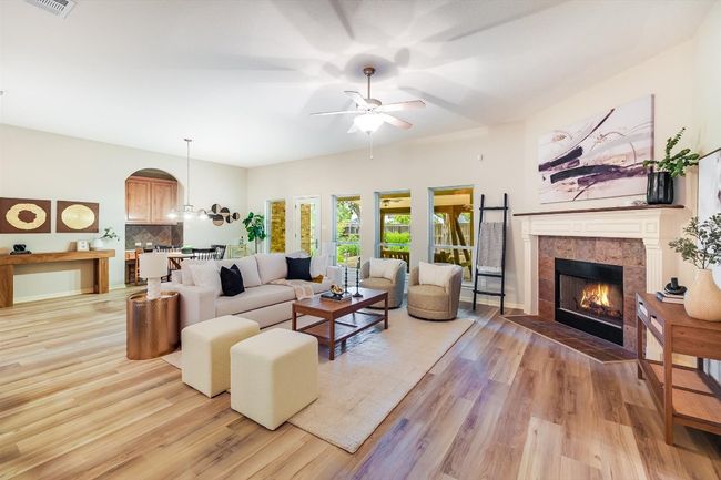 Living room featuring a ceiling fan, a fireplace, and light wood-style flooring | Image 16