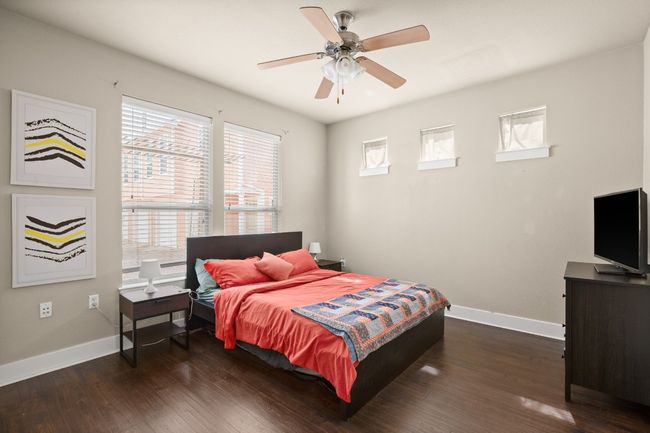Bedroom with dark wood finished floors, baseboards, and ceiling fan | Image 6
