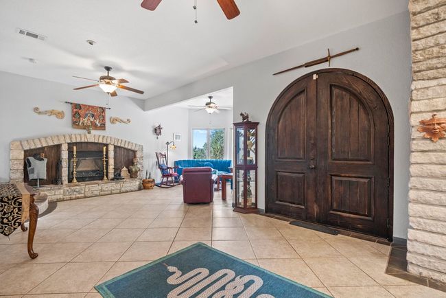 Entrance foyer with visible vents, a fireplace with raised hearth, and light tile patterned flooring | Image 4